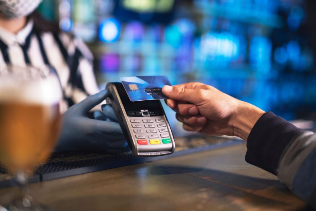 pub payment processing customer paying at bar POS terminal